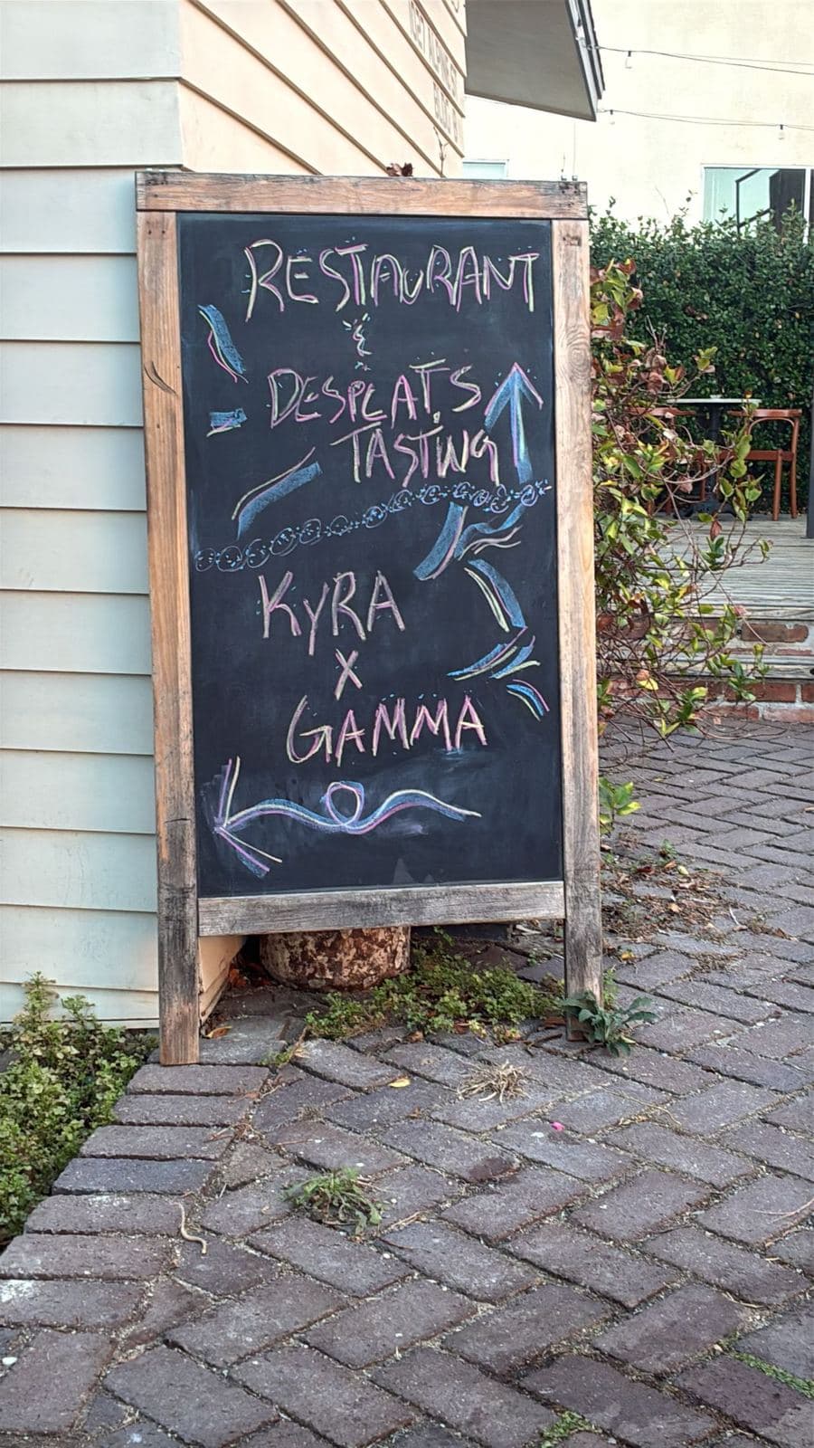 Chalkboard sign for the Kyra x Gamma dinner at Baby Bistro in Los Angeles, October 2026